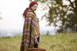 A young woman wrapped in a blanket, holding a wicker basket