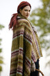 A young woman wrapped in a blanket, holding a wicker basket