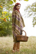 A young woman wrapped in a blanket, holding a wicker basket