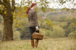 A young woman walking through a field holding a wicker basket