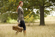 A young woman walking through a field, holding a wicker basket