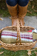 Close-up of a young woman's feet and wicker basket