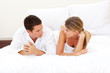 Young couple discussing lying on their bed