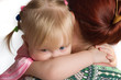 Little daughter embraces mum for a neck.