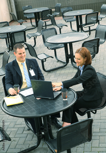 Photo: Two Business People Sit Outdoor Two Business People Sit Outdoor
