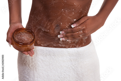 Photo: Exfoliation Woman Putting scrub on abdomen Exfoliation Woman Putting scrub on abdomen