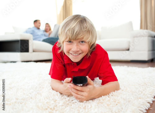 Smiling boy watching TV lying on the floor Smiling boy watching TV lying on the floor