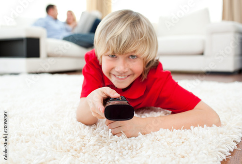 Jolly boy watching TV lying on the floor Jolly boy watching TV lying on the floor