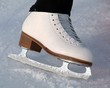 Schlittschuh einer Eiskunstläuferin auf dem Eis. Sample text.