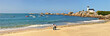 panorama of the beach with a lighthouse and a couple