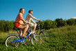 girl and man go for drive on bicycles in sunny day