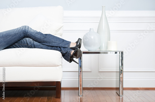 Photo: Woman's Leg's Reclining on White Couch Woman's Leg's Reclining on White Couch