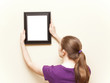 Details der Fotografie Young woman hanging a picture frame.