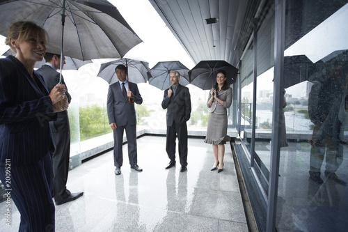 Photo: Businessteam with umbrellas Businessteam with umbrellas