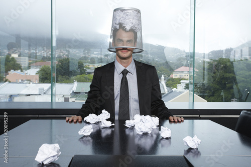 Photo: Businessman with a trash box on his head Businessman with a trash box on his head