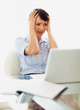 Tensed business woman holding her head in front of laptop