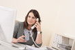 Young woman talking on the phone at office