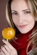 A mid adult woman holding a toffee apple