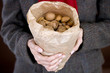 A woman holding a bag full of mixed nuts