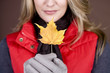 A mid adult woman holding an autumn leaf