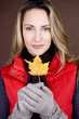 A mid adult woman holding an autumn leaf