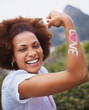 Laughing female flexing arms with "love" tattooed on it