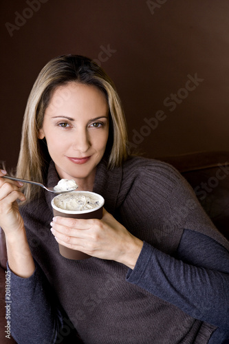 Photo: A mid adult woman eating ice cream A mid adult woman eating ice cream