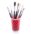 a group of paint brushes in a red dotted cup