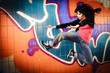 Attraktive Frau hebt ab vor Graffity Wand