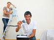 Smiling couple painting a wall