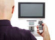 Mann mit Fernbedienung vor Fernseher