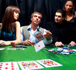 Stylish man in black suit folds two cards in casino