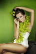 Portrait of a young brunette beauty over green wall