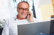 mature man with laptop mobilephone and reading specs mature man with laptop mobilephone and reading specs