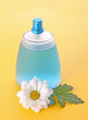 Bottle of perfume  and  camomile on yellow background