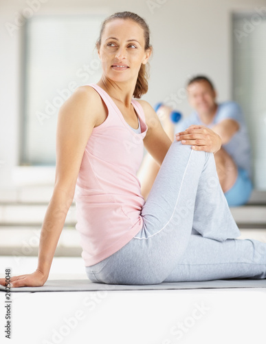 Attractive woman doing physical exercise on a yoga mat