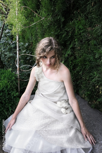 Foto: Beautiful girl sitting in the garden Beautiful girl sitting in the garden