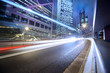 Fast moving cars lights blurred over modern city background