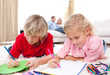 Cute siblings drawing lying on the floor