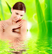 Woman with grass frame around her reflected in water
