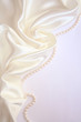 Smooth elegant white silk with pearls as wedding background Smooth elegant white silk with pearls as wedding background