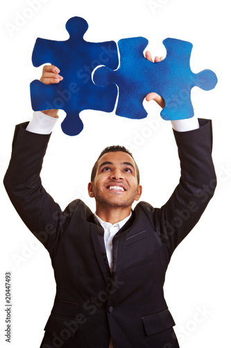 Photo: Geschäftsmann löst großes Puzzle Geschäftsmann löst großes Puzzle