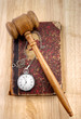 Judge's gavel and very old legal book with watch