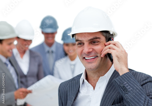 Photo: Mature male architect on phone standing Mature male architect on phone standing