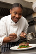 Chef Adding Sauce To Dish In Restaurant Kitchen