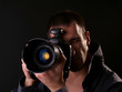 young male photographer trying out his new camera in studio