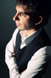 Photo: Young business man with folded arms before gray background Young business man with folded arms before gray background