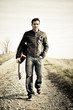 Foto: musician with guitar walking along the road musician with guitar walking along the road