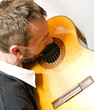 homme joue de la guitare avec émotion