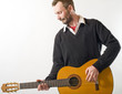 homme joue de la guitare avec émotion